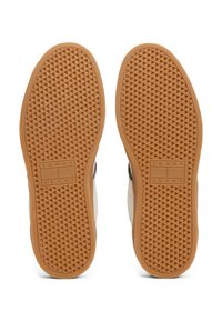Barna gumis sneaker talp, amelyen egy texturált gyémántmintázat található, a "TOMMY JEANS" márkázással. Az anyag bézs és tengerészkék kiegészítőkkel ötvözve.