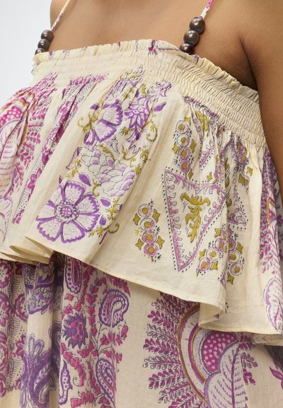 Robe bustier beige avec des motifs floraux et cachemire violets et jaunes, avec un haut à volants et des bretelles marron ornées de perles.