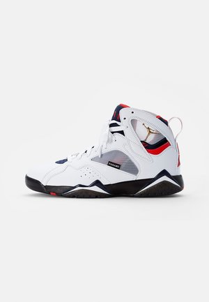 Basket montante blanche avec des accents noirs, rouges et bleu marine, panneau latéral en mesh, logo Jumpman doré et étiquette "PANAME" sur le côté.