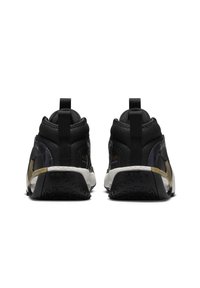 Scarpe da ginnastica nere e dorate con superiore in tessuto testurizzato, suola in gomma e linguette sul tallone; accenti dorati notevoli sui lati.