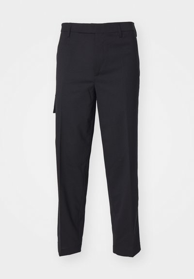 Pantalones negros hechos de una tela tejida suave. Cuentan con un corte recto, ajuste slim, presillas para cinturón y un bolsillo lateral.