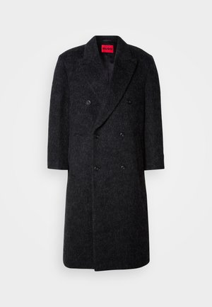 Double-breasted long dark gray wool coat with six black buttons, notch lapels, and a red label inside the collar.