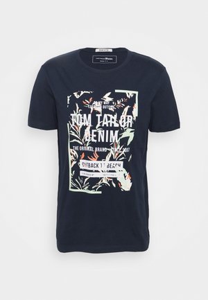 Mørkeblå bomulds T-shirt med korte ærmer, prydet med et blomsterdesign og hvid tekst i en rektangulær ramme.