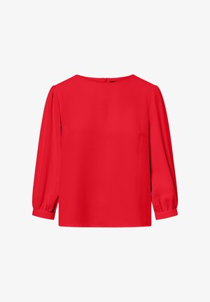 Piros blúz sima anyagból, kerek nyakkivágással, hosszú puffos ujjakkal és diszkrét hátsó cipzárral. Tiszta, egyenes vonalú design.