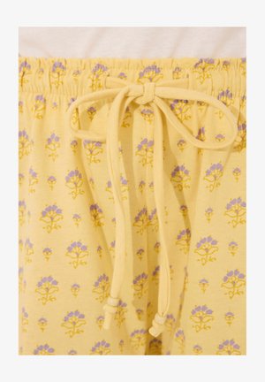 Gele katoenen broek met een elastische tailleband, voorzien van een bloemenpatroon in paars en geel. Zachte textuur, casual ontwerp dat geschikt is voor loungekleding.