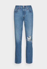 Jeans de mezclilla azul con pierna recta, cintura alta y rodilla desgastada. Presenta un cierre de botón metálico y un diseño clásico de cinco bolsillos.