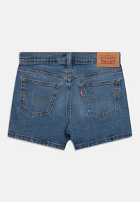 Jeansshorts i medelblått med rak skärning. Har två bakfickor, kontrasterande sömmar och en märkesläderpatch vid midjan.