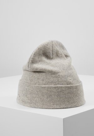 Light gray knitted beanie with folded cuff displayed on white pedestal against plain gray background.