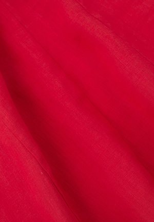 Jasnoczerwony len o gładkiej fakturze, z delikatnymi naturalnymi wzorami tkackimi i subtelnymi odcieniami kolorów.