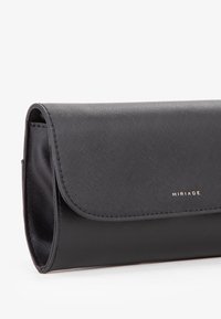 Borsa a pochette nera realizzata in materiale testurizzato con chiusura a patta, caratterizzata da un logo dorato e sottili dettagli di cucitura. Forma rettangolare.