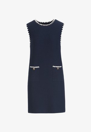 Vestido sin mangas azul marino en tela texturizada, con ribete blanco con ondas, dos bolsillos delanteros y botones dorados en los bolsillos.