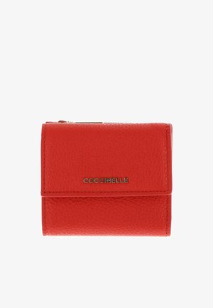 Portefeuille compact en cuir rouge texturé avec une fermeture éclair dorée et le logo "Coccinelle" sur le rabat avant.