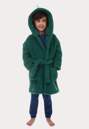 Grüner, flauschiger Fleece-Bademantel mit Kapuze, gebundenem Gürtel und Vordertaschen, kombiniert mit blauen Hosen. Der Bademantel hat ein weiches, strukturiertes Finish.