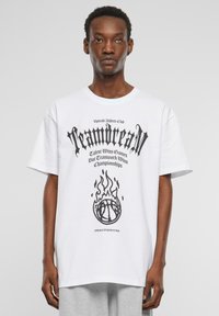 Hvid bomulds T-shirt med sort grafisk tekst og en basketball-illustration med flammer. Løs pasform, korte ærmer, rund halsudskæring.
