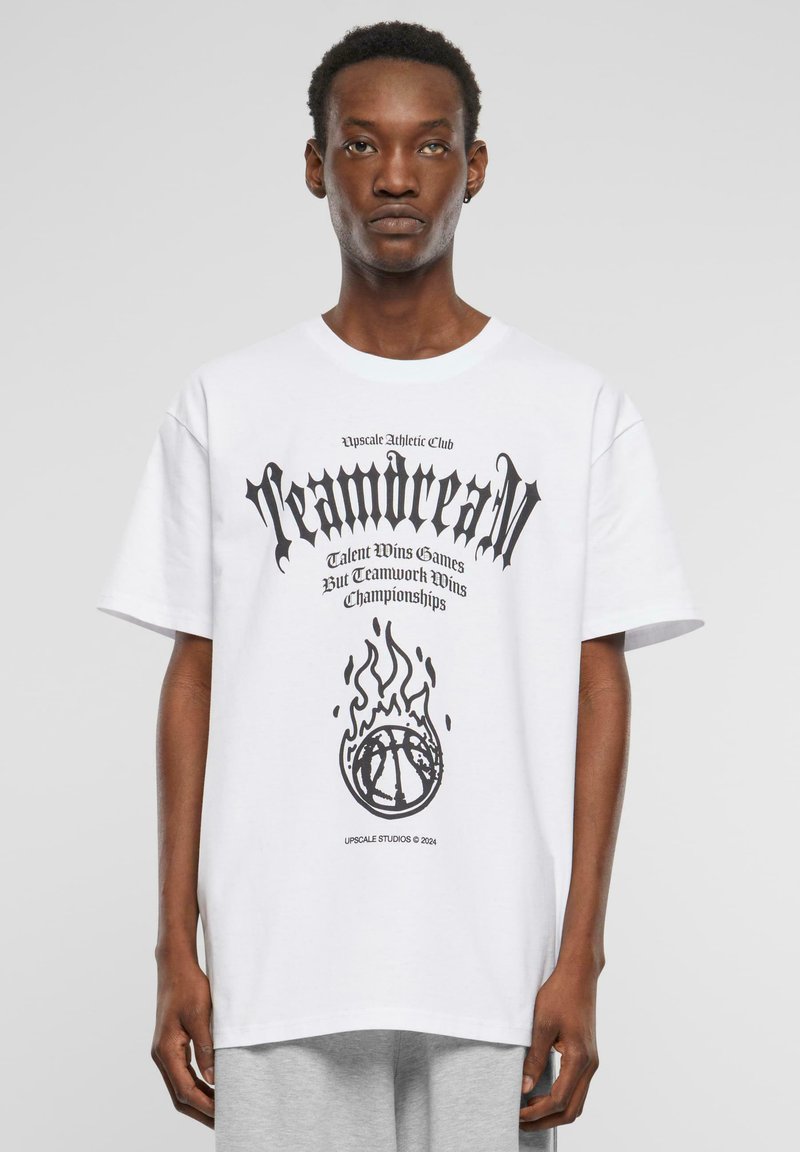 Hvid bomulds T-shirt med sort grafisk tekst og en basketball-illustration med flammer. Løs pasform, korte ærmer, rund halsudskæring.