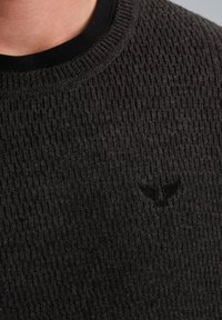 Dunkles, strukturiertes Sweatshirt mit einem gerippten Design, runder Halslinie und einem dezenten, gestickten Logo-Akzent auf der Brust.