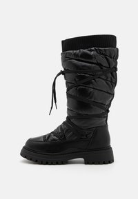 Black thigh-high boots with a puffy, quilted nylon upper and rubber sole. Features a ribbed cuff and crisscross laces for adjustment.