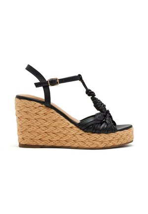 Sandale compensée en cuir tressé noir avec semelle en jute tressé, sangle de cheville réglable et sangle de orteil texturée noire.