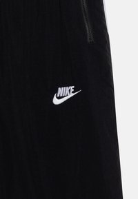 Nike Sportswear AMPLIFY UNISEX - Tracksuit bottoms - black/dark smoke grey/white