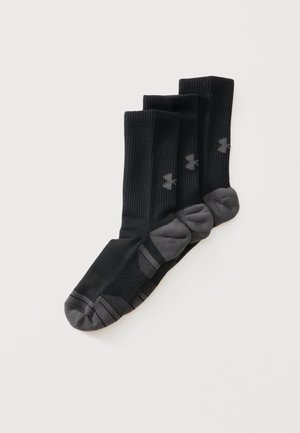 Drei Paar schwarze und graue Sportsocken mit Bündchen nebeneinander auf weißem Hintergrund angeordnet.