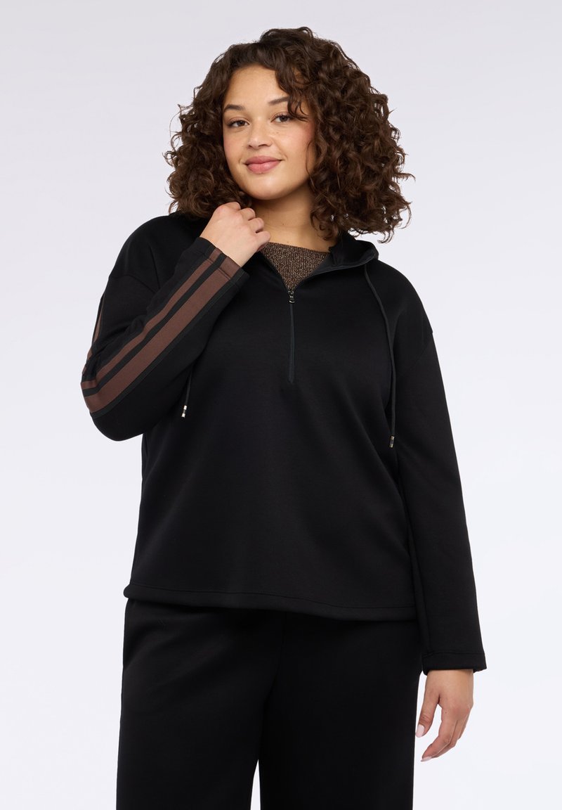 Sudadera negra con capucha y cremallera de cuarto, con franjas marrones en las mangas. Tela suave con un ajuste relajado y mangas largas.