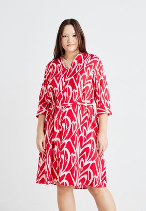 Vestido de patrones rojos y blancos con un diseño envolvente, mangas cortas y un cinturón atado, que presenta una silueta fluida y una textura suave.