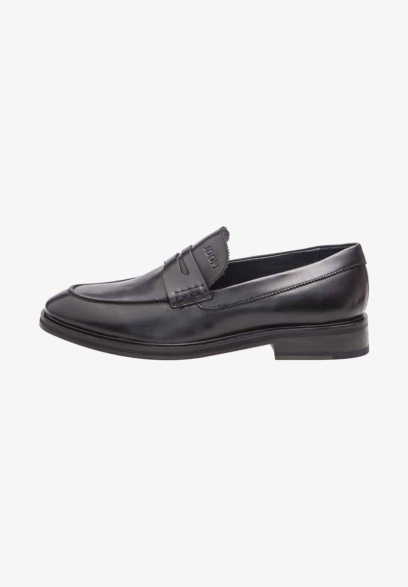 Black leather loafer with a flat heel, rounded toe, and decorative stitching. Features a raised strap across the upper with embossed branding.