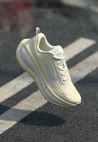 Weißer Nike-Laufschuh mit einem strukturierten Mesh-Obermaterial, glatter Sohle und subtilen Branding-Elementen. Leichtes Design, ideal für sportliche Nutzung.