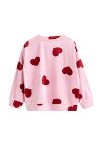 Lyserød sweatshirt med røde hjerte mønstre. Har lange ærmer, en rund halsudskæring og en blød tekstur. Kun bagfra.