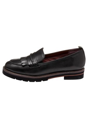 Mocassin noir en cuir avec détail frangé, bout rond, petit talon et semelle cousue, montré de profil sur fond blanc.
