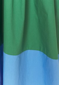 Tissu en coton présentant un design bicolore : la section supérieure en vert et la section inférieure en bleu clair, avec une texture lisse et une drapé doux.