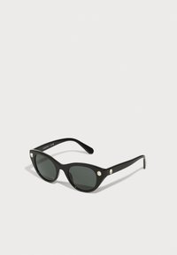 Ochelari de soare negri, tip cat-eye, cu lentile întunecate, cadru din plastic lucios și două accente decorative în partea frontală, aproape de tâmple.