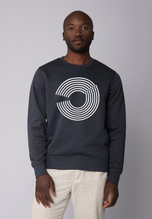Navyblauwe sweatshirt van zachte stof met een witte cirkelvormige, gestreepte grafische vormgeving op de voorkant. Lange mouwen en geribbelde manchetten.