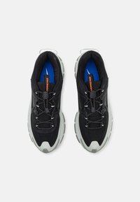 Black athletic shoes with textured fabric, elastic laces, and a cushioned sole in light gray, featuring a blue insole and orange branding.