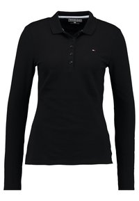 Czarna koszulka polo z długim rękawem wykonana z bawełny. Posiada trzy guziki, kołnierzyk oraz małe logo po lewej stronie klatki piersiowej.