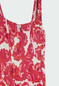 Robe sans manches avec un motif floral rouge et rose sur fond blanc, dotée d'un décolleté carré et d'un corsage ajusté.