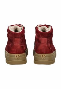 Bottines en suède rouge à talon avec des semelles en caoutchouc texturé beige. Dotées d'un doublage en fourrure, d'une fermeture éclair et d'un logo en relief sur le talon.