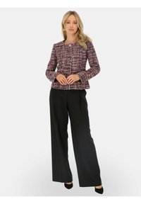 Fioletowa marynarka z tweedu z okrągłym dekoltem i długimi rękawami, zestawiona z czarnymi spodniami o szerokich nogawkach i czarnymi szpilkami. Gładka tekstura i dopasowany krój.