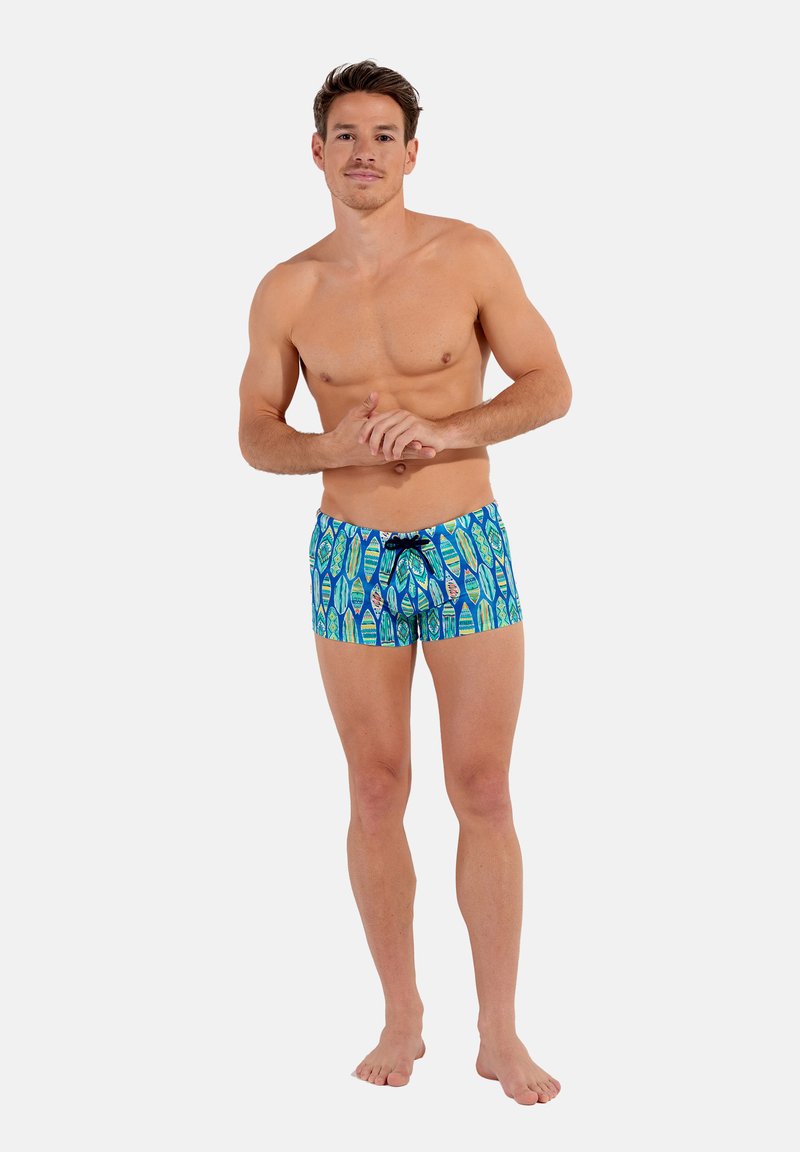 Badehosen in Blau mit einem lebendigen Muster aus grünen und pinken Designs, ausgestattet mit einem schwarzen Kordelzug, aus leichtem Stoff.
