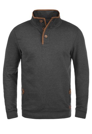 Tummanharmaa huppari, jossa on korkea kaulus, kolme ruskeaa nappia ja ristikkäisiä ruskeita yksityiskohtia kauluksessa ja sivuilla. Pehmeä tekstuuri.