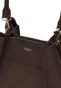 Borsa a tracolla in pelle marrone con un design strutturato, hardware dorato e un logo sottile sul fronte. Texture liscia con dettagli cuciti.