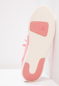 Adidas-sko med en rosa stickad ovandel, texturerad sula och en vit botten med rosa kontur och logodetaljer.