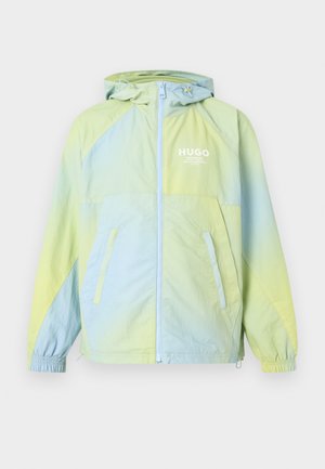 Kevyt hupullinen takki, jossa vaaleankeltaiset ja siniset liukuvärit, edessä vetoketju, joustavat hihansuut, kaksi sivutaskua ja rintataskussa "HUGO"-logo.