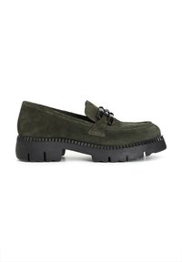 Mocassini verde in suede con suola in gomma nera texturizzata e dettagli decorativi in metallo nero sulla parte superiore. Design della punta leggermente arrotondata.