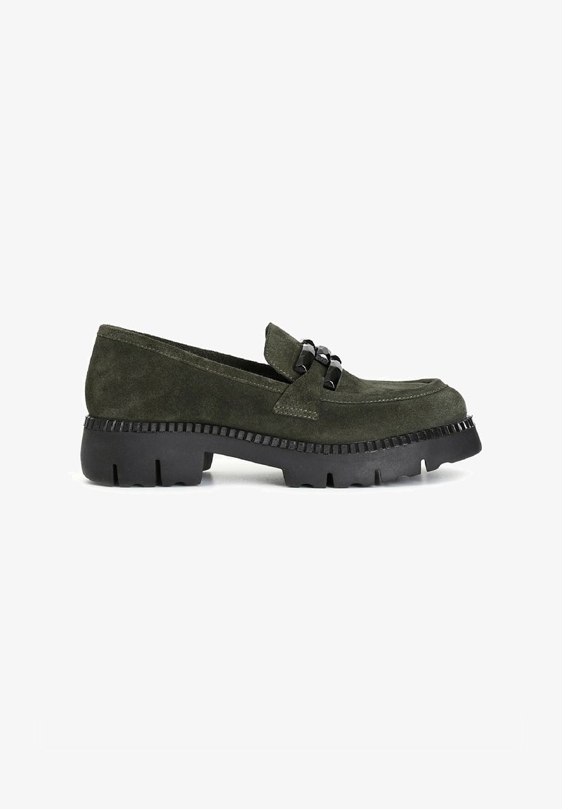 Mocasines verdes de ante con una suela de goma negra texturizada y acentos decorativos de hardware negro en la parte superior. Diseño de punta ligeramente redondeada.