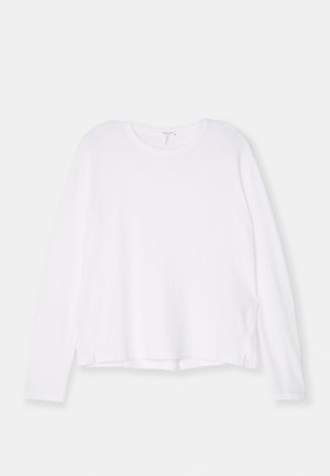 Camisa branca de manga longa feita de tecido suave, com decote redondo, corte descontraído e fendas laterais na bainha para facilitar os movimentos.