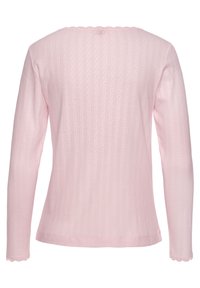 Langsleeve roze top van ribbelstof, met een golvende halslijn en een textuurdetail met een subtiel patroon door het geheel.