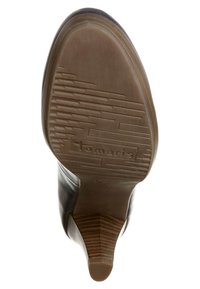 Svart läderstövel med en texturerad gummisula. Har en avsmalnad klack och en varumärkeslogotyp "Tamaris" präglad på sulan.