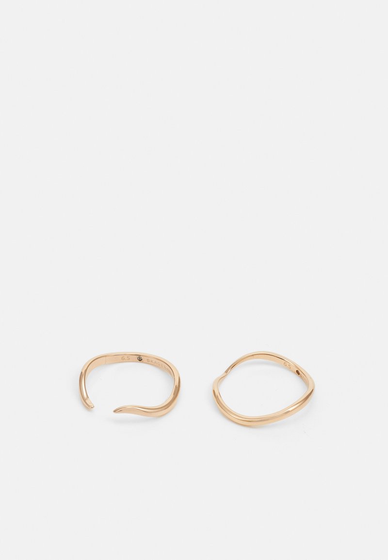 Anelli in tono oro con un design minimalista e bordi lisci e arrotondati. Un anello ha una forma aperta, mentre l'altro è leggermente squadrato.