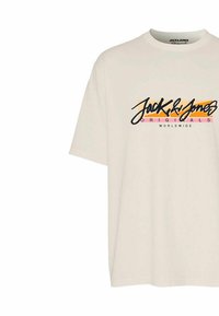 Camiseta crema de algodón con mangas cortas, que presenta un diseño de logotipo colorido que incluye texto en negro, naranja y rosa.
